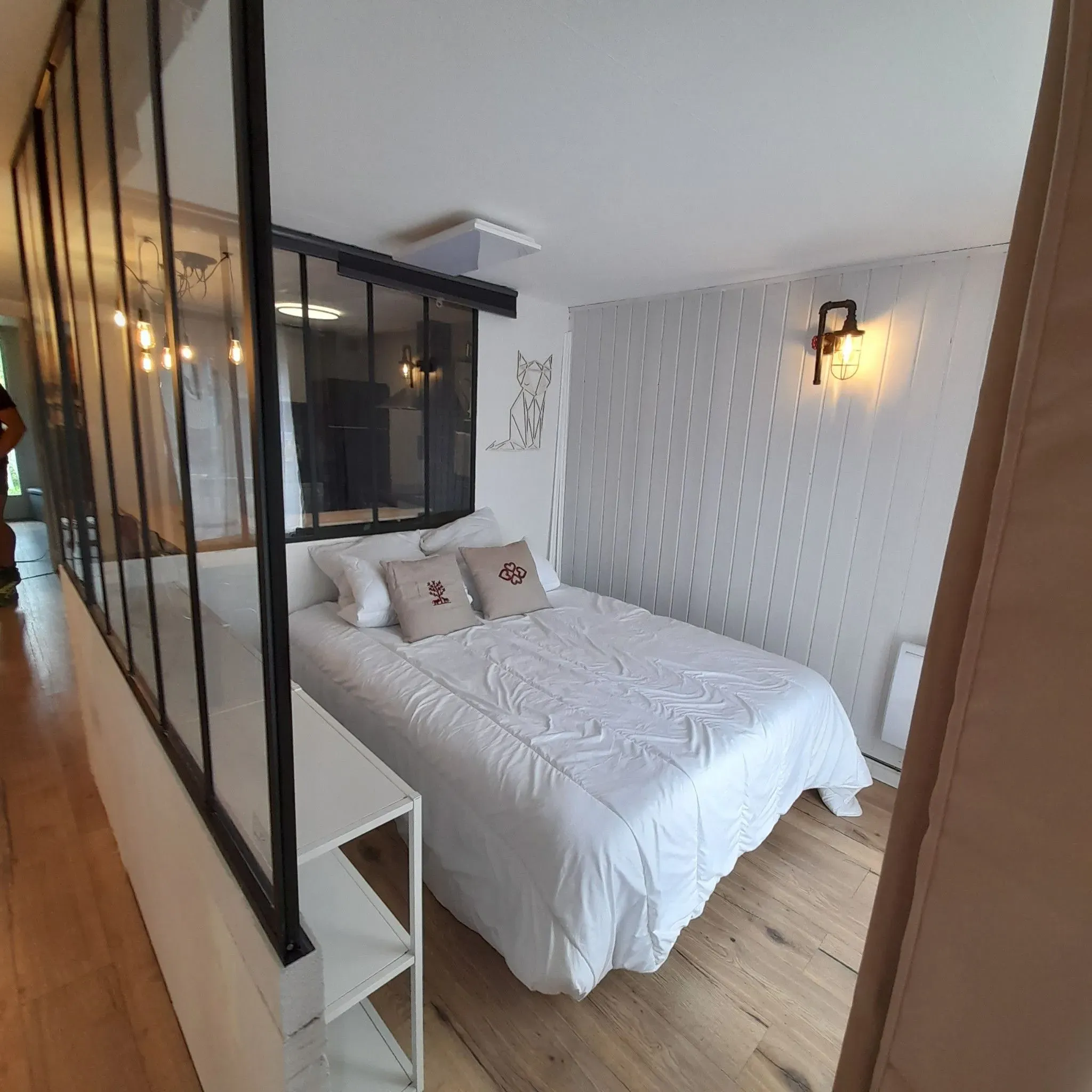 Chambre avec lit double derrière la verrière